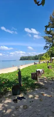 a person with an umbrella standing on a beach at Dewa One bedroom suite in Nai Yang Beach