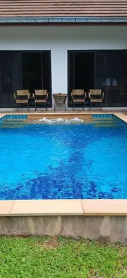 a large blue swimming pool with benches in front of a building at Wow !! Super Cool !! Jungle View Pool Villa !! Krabi - Thailand in Krabi town