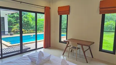 a bedroom with a desk and a table and windows at Wow !! Super Cool !! Jungle View Pool Villa !! Krabi - Thailand in Krabi town
