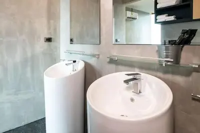 a bathroom with a white sink and a mirror at 360* Ultimate Penthouse Entire TOP FLOOR and RESORT with GREAT AMENITIES in Kamala Beach