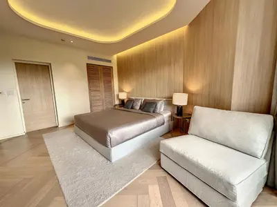 a bedroom with a bed and a white couch at Stylish 1 Bedroom Apartment with Golf View, Steps from Bang Tao Beach, Allamanda Laguna in Bang Tao Beach