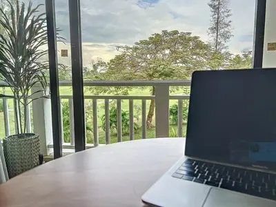 a laptop computer sitting on a table on a balcony at Stylish 1 Bedroom Apartment with Golf View, Steps from Bang Tao Beach, Allamanda Laguna in Bang Tao Beach