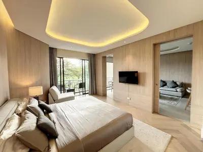 a bedroom with a large bed and a flat screen tv at Stylish 1 Bedroom Apartment with Golf View, Steps from Bang Tao Beach, Allamanda Laguna in Bang Tao Beach
