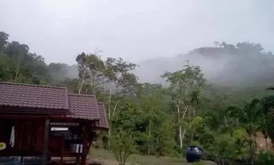 a house with a view of a misty forest at Kanda Hill Resort in Ban Na Sok