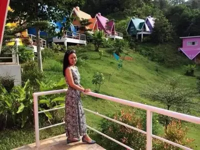 a woman in a dress standing next to a rail at Kanda Hill Resort in Ban Na Sok