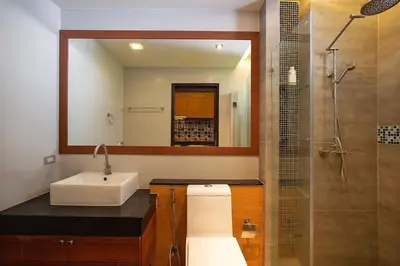 a bathroom with a sink and a shower with a mirror at Seaside Haven Karon in Karon Beach