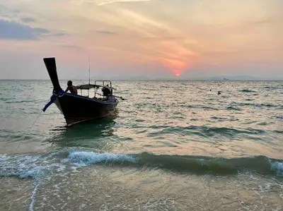 a man is in a boat in the ocean at Chez Wanida - apartment Krabi in Klong Muang Beach