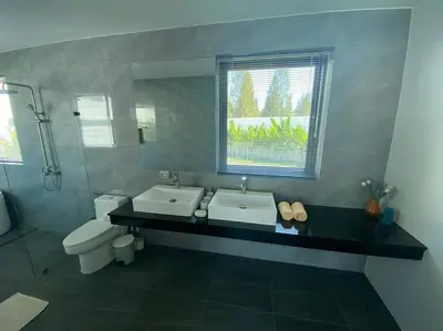a bathroom with two sinks and a toilet and a window at Costa Lota villa, brand new, 3 bedroom, in rawai V35 in Rawai Beach