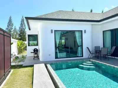 a villa with a swimming pool in front of a house at Costa Lota villa, brand new, 3 bedroom, in rawai V35 in Rawai Beach