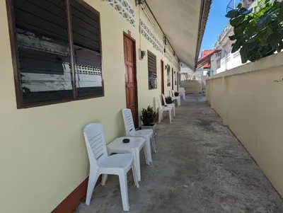 a row of white chairs sitting outside of a building at Rawai-Casevacanze in Rawai Beach