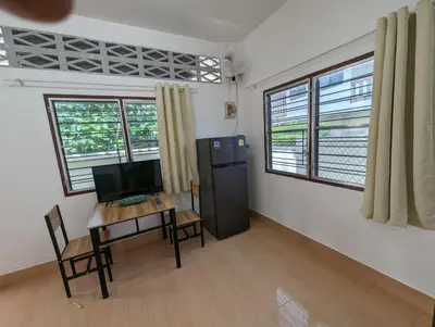 a room with a desk and a refrigerator and a table at Rawai-Casevacanze in Rawai Beach