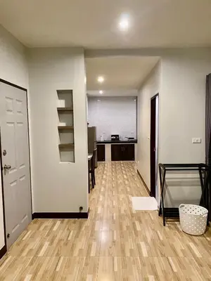 an empty room with a kitchen and a hallway with wooden floors at Hm House Patong in Patong Beach