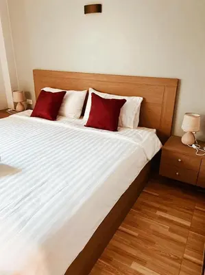 a bedroom with a large bed with two red pillows at Hm House Patong in Patong Beach