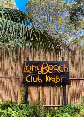 a sign on a fence in front of a building at Long Beach Club Krabi in Ban Nong Thale