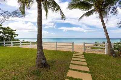 two palm trees and a path on the beach at Carpe Diem Beach Villa in Natai Beach