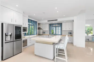 a kitchen with white cabinets and a white counter top at Carpe Diem Beach Villa in Natai Beach
