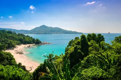 a view of a beach with people in the water at Kamala Havana Hotel and Cafe in Kamala Beach