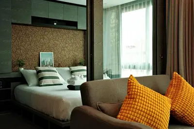 a bedroom with a bed and a couch and a window at City Gate Kamala D305 by Phuket Sabay Rent in Phuket Town