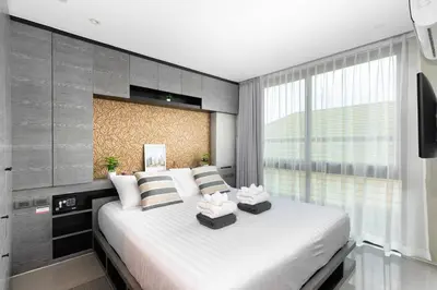 a bedroom with a large white bed with pillows at City Gate Kamala D305 by Phuket Sabay Rent in Phuket Town