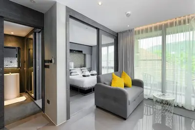 a bedroom with a bed and a couch in a room at City Gate Kamala D305 by Phuket Sabay Rent in Phuket Town
