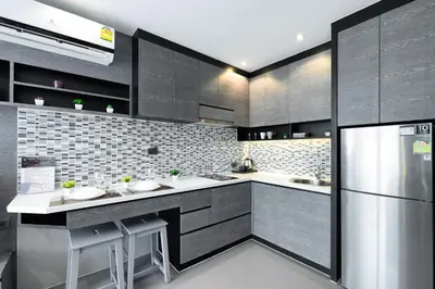 a kitchen with black cabinets and a stainless steel refrigerator at City Gate Kamala D305 by Phuket Sabay Rent in Phuket Town