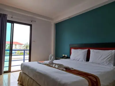 a bedroom with a bed with a stuffed animal on it at Desa Phuket in Phuket Town
