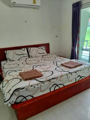 a bedroom with a large bed with brown pillows at Firdous Guesthouse in Ko Yao Yai