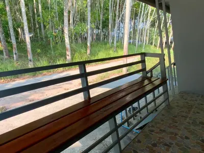 a bench in a room with a view of a forest at Firdous Guesthouse in Ko Yao Yai