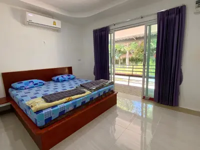 a bedroom with a bed and a sliding glass door at Firdous Guesthouse in Ko Yao Yai