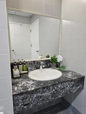 a bathroom counter with a sink and a mirror at Patong Tower Apartment in Patong Beach