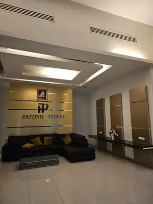 a living room with a couch and a sign on the wall at Patong Tower Apartment in Patong Beach