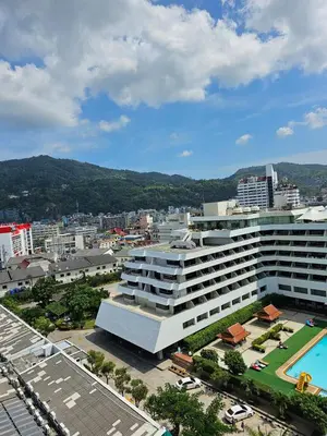 a large white building with a pool in a city at Patong Tower Apartment in Patong Beach