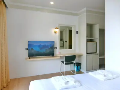 a bedroom with a bed and a chair and a tv at Sira Boutique, Patong in Patong Beach