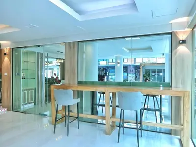 a dining room with a wooden table and stools at Sira Boutique, Patong in Patong Beach