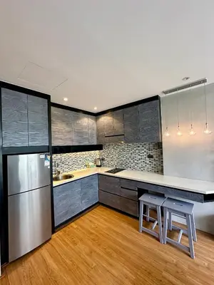 a kitchen with stainless steel appliances and wooden floors at Stylish apartments Kamala CityGate in Kamala Beach