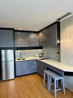 a kitchen with gray cabinets and a stainless steel refrigerator at Stylish apartments Kamala CityGate in Kamala Beach