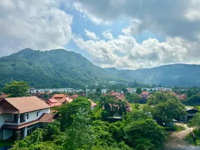 a view of a village with mountains in the background at Stylish apartments Kamala CityGate in Kamala Beach
