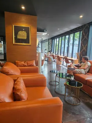 a lobby with orange leather couches and a man sitting on a couch at Stylish apartments Kamala CityGate in Kamala Beach