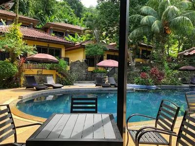 a pool at a resort with a table and chairs at the hill resort \u5e0c\u5c14\u5ea6\u5047\u5c4b in Patong Beach