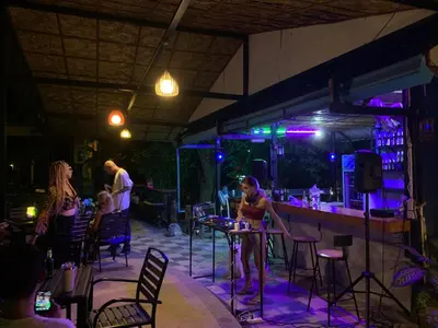 a woman standing at a bar in a nightclub at the hill resort \u5e0c\u5c14\u5ea6\u5047\u5c4b in Patong Beach