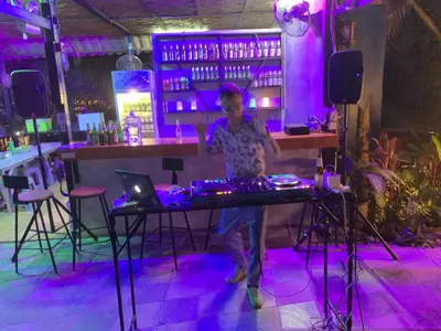 a man standing behind a table in a bar at the hill resort \u5e0c\u5c14\u5ea6\u5047\u5c4b in Patong Beach