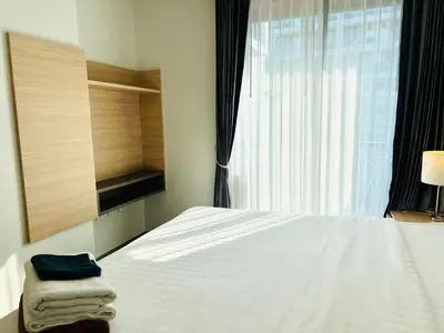 a bedroom with a white bed and a window at Modern style 1BR Condo close to Kata beach in Kata Beach