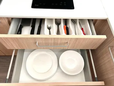 a cabinet filled with white plates and utensils at Modern style 1BR Condo close to Kata beach in Kata Beach