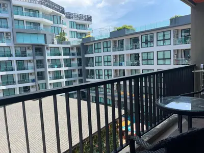 a balcony with a table and some buildings at Modern style 1BR Condo close to Kata beach in Kata Beach