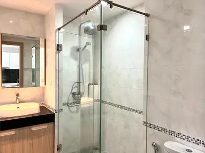 a bathroom with a glass shower and a sink at Modern style 1BR Condo close to Kata beach in Kata Beach