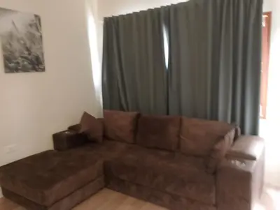 a brown couch in a living room with a window at Bonanza Patong Beach1 100m to Beach Sun Room in Patong Beach