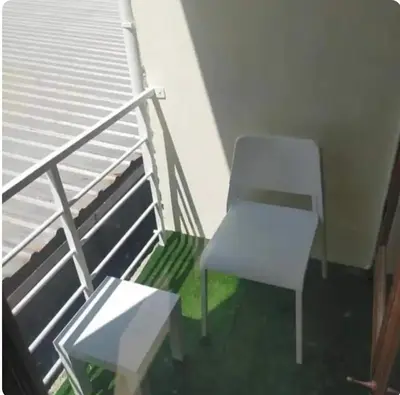 a white chair sitting on top of a balcony at Bonanza Patong Beach1 100m to Beach Sun Room in Patong Beach