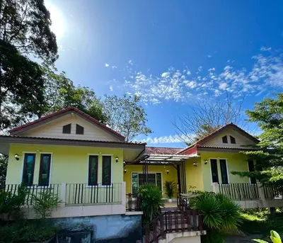 a yellow house with a porch at Villa Patong in Ban Na Nai