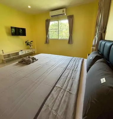 a bedroom with a large bed in front of a window at Villa Patong in Ban Na Nai