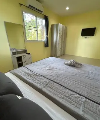 a large bed in a bedroom with a window at Villa Patong in Ban Na Nai